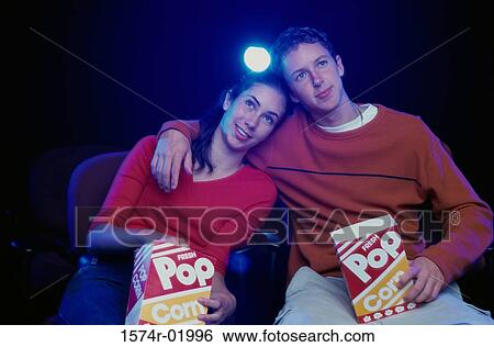 Teenage couple watching a movie in a theater View Large Photo Image Stock Photograph - Teenage couple watching a movie in a theater. Fotosearch