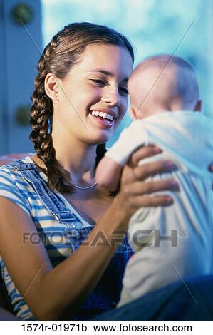 Teenage girl holding a baby View Large Photo Image Stock Image - Teenage girl holding a baby. Fotosearch