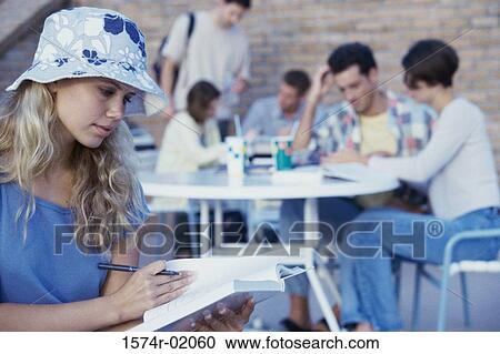 Teenagers seated at tables outdoors View Large Photo Image Stock Image - Teenagers seated at tables outdoors. Fotosearch