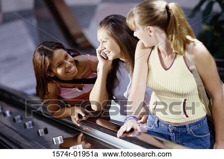 Three teenage girls standing on an escalator View Large Photo Image Stock Image - Three teenage girls standing on an escalator. Fotosearch