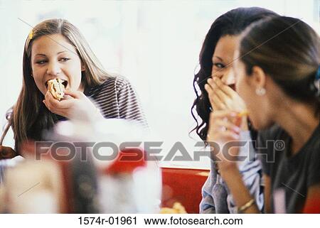 Three young women eating at a cafe View Large Photo Image Stock Image - Three young women eating at a cafe. Fotosearch