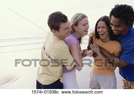 Stock Image - Two teenager couples at the beach. Fotosearch