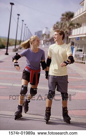 Young couple holding hands in-line skating View Large Photo Image Stock Image - Young couple holding hands in-line skating. Fotosearch