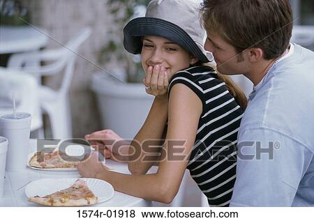 Stock Photo - Young couple sitting at a table outdoors. Fotosearch