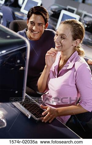 Young man and a young woman looking at a computer monitor View Large Photo Image Stock Image - Young man and a young woman looking at a computer monitor. Fotosearch