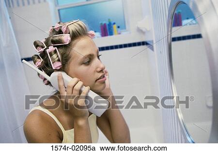 Young woman with curlers in her hair talking on a telephone View Large Photo Image Stock Image - Young woman with curlers in her hair talking on a telephone. Fotosearch