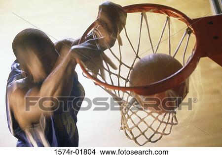 Picture - Basketball player slam dunking a ball. Fotosearch
