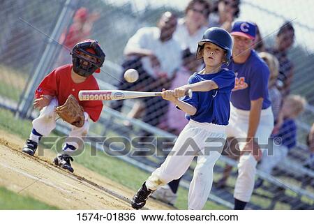 Boy swinging a baseball bat on a field View Large Photo Image Stock Photograph - Boy swinging a baseball bat on a field. Fotosearch