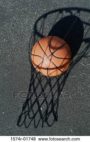 Close-up of a basketball resting on the shadow of a basketball hoop View Large Photo Image Stock Photo - Close-up of a basketball resting on the shadow of a basketball hoop. Fotosearch