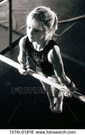 Girl performing gymnastics on uneven parallel bars View Large Photo Image Stock Photograph - Girl performing gymnastics on uneven parallel bars. Fotosearch
