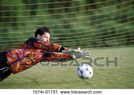 Goalie diving on a field to save the ball View Large Photo Image Stock Image - Goalie diving on a field to save the ball. Fotosearch