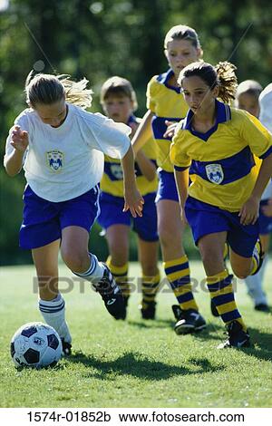 Stock Image - Group of girls playing soccer. Fotosearch
