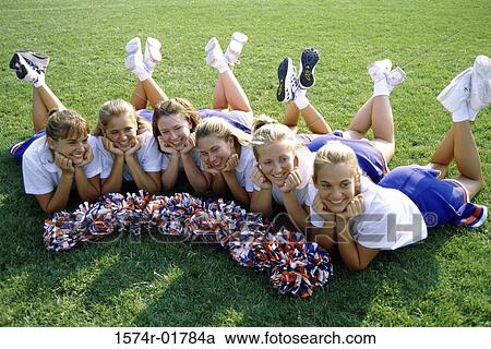 High angle view of cheerleaders lying on a lawn View Large Photo Image Stock Image - High angle view of cheerleaders lying on a lawn. Fotosearch