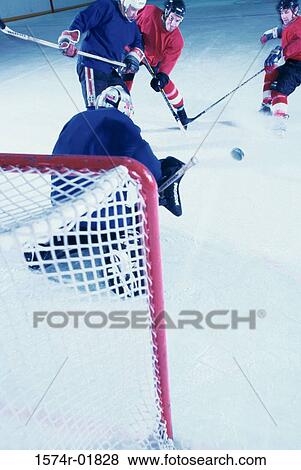 Stock Photo - High angle view of ice hockey players surrounding the goal. Fotosearch
