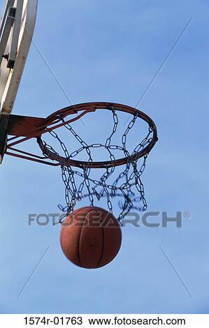 Low angle view of a basketball going through the hoop View Large Photo Image Stock Image - Low angle view of a basketball going through the hoop. Fotosearch