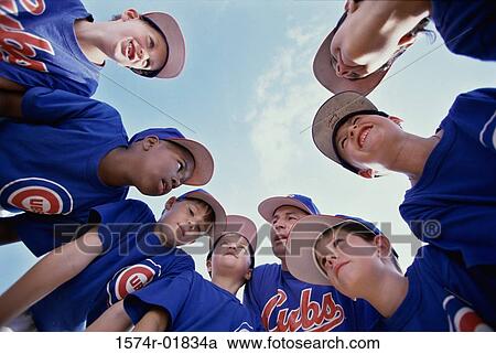Stock Image - Low angle view of a little league baseball team in a huddle. Fotosearch