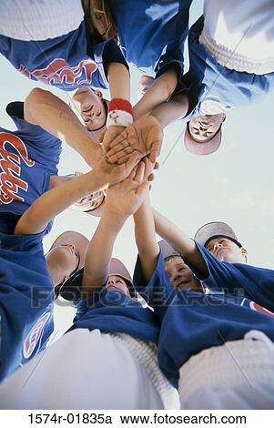 Stock Image - Low angle view of a little league baseball team in a huddle. Fotosearch