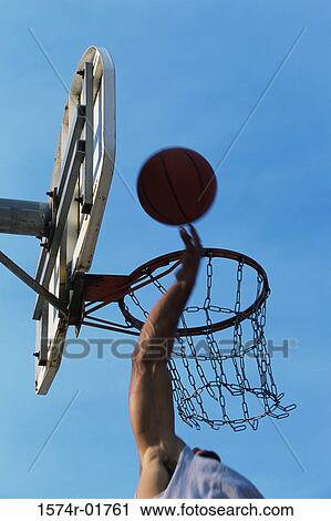 Low angle view of a person's hand shooting a basketball into the hoop View Large Photo Image Stock Image - Low angle view of a person's hand shooting a basketball into the hoop. Fotosearch