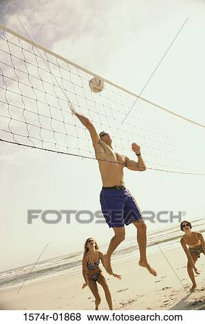 Low angle view of three people playing volleyball on the beach View Large Photo Image Stock Photo - Low angle view of three people playing volleyball on the beach. Fotosearch