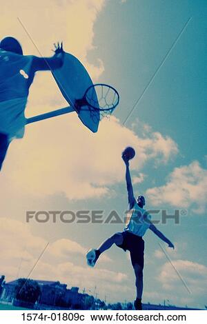 Stock Image - Low angle view of two men playing basketball. Fotosearch