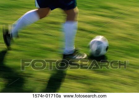 Low section view of a soccer player running with the ball View Large Photo Image Stock Image - Low section view of a soccer player running with the ball. Fotosearch
