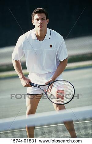 Stock Image - Portrait of a young man playing tennis. Fotosearch