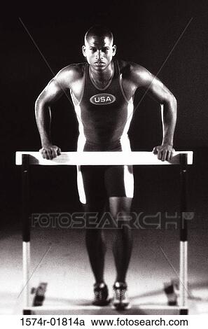 Portrait of a young man standing against a hurdle View Large Photo Image Stock Image - Portrait of a young man standing against a hurdle. Fotosearch