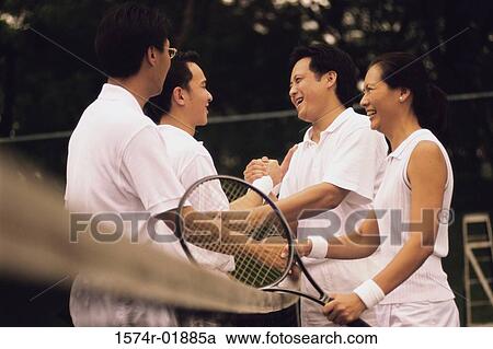 Stock Image - Side profile of tennis players shaking hands over a net. Fotosearch