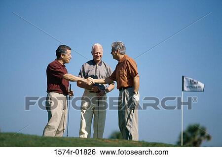 Stock Photograph - Three people shaking hands at a golf course. Fotosearch