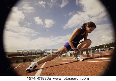 Young female athlete stretching on a running track View Large Photo Image Stock Image - Young female athlete stretching on a running track. Fotosearch