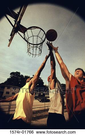 Stock Photograph - Young men playing basketball. Fotosearch
