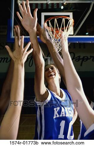 Stock Image - Young women reaching for a basketball. Fotosearch