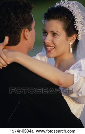 Stock Image - Bride hugging her groom. Fotosearch