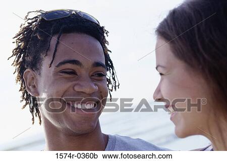 Stock Image - Close-up of a teenage couple looking at each other. Fotosearch