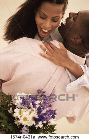 Stock Image - Couple holding flowers. Fotosearch