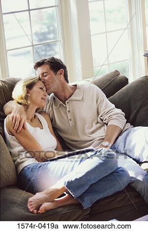 Couple sitting on a couch View Large Photo Image Stock Image - Couple sitting on a couch. Fotosearch