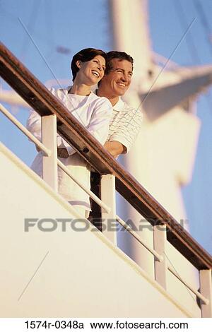 Stock Image - Low angle view of a couple on a ship. Fotosearch