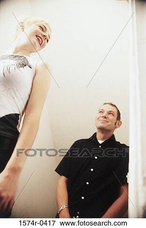 Low angle view of a young couple View Large Photo Image Stock Photo - Low angle view of a young couple. Fotosearch