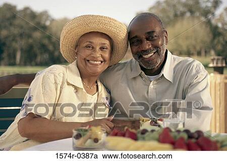 Stock Image - Portrait of a senior couple sitting together outdoors. Fotosearch
