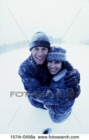 Portrait of a young couple holding each other standing in the snow View Large Photo Image Stock Image - Portrait of a young couple holding each other standing in the snow. Fotosearch