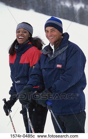 Portrait of a young couple standing with skiing equipment outdoors View Large Photo Image Stock Image - Portrait of a young couple standing with skiing equipment outdoors. Fotosearch