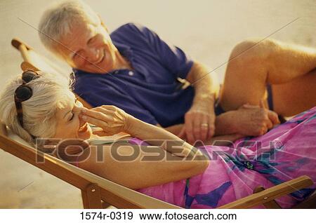 Senior couple sitting on beach chairs View Large Photo Image Stock Photo - Senior couple sitting on beach chairs. Fotosearch