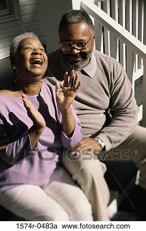 Stock Image - Senior couple sitting on stairs laughing. Fotosearch