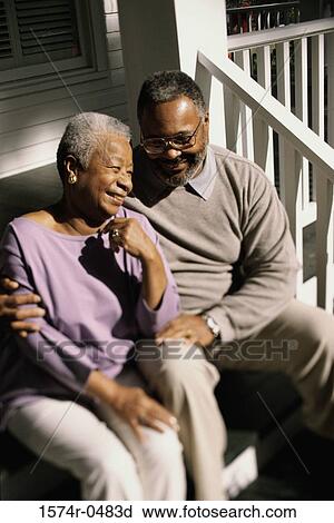 Stock Image - Senior couple sitting on stairs laughing. Fotosearch