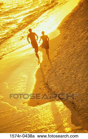Silhouette of a young couple running at the beach View Large Photo Image Stock Image - Silhouette of a young couple running at the beach. Fotosearch