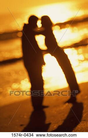 Silhouette of a young couple together at the beach View Large Photo Image Picture - Silhouette of a young couple together at the beach. Fotosearch