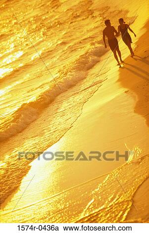 Silhouette of a young couple walking together at the beach View Large Photo Image Stock Image - Silhouette of a young couple walking together at the beach. Fotosearch
