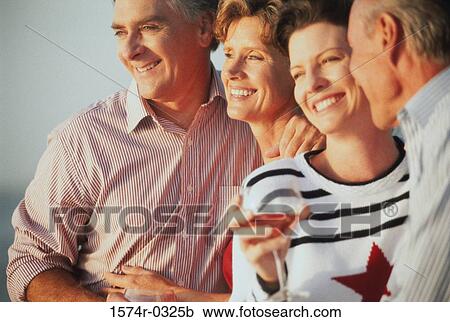 Stock Image - Two couples standing together. Fotosearch
