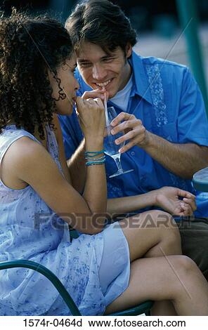 Young couple drinking together from a glass with straws View Large Photo Image Stock Image - Young couple drinking together from a glass with straws. Fotosearch