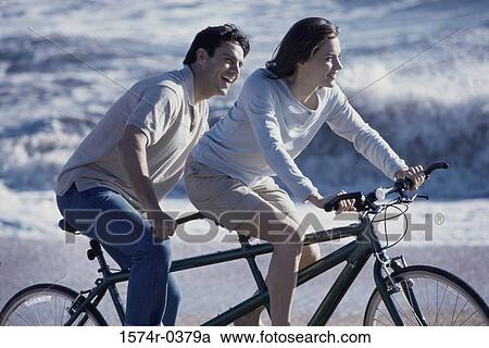Young couple riding a tandem bicycle at the beach View Large Photo Image Stock Image - Young couple riding a tandem bicycle at the beach. Fotosearch